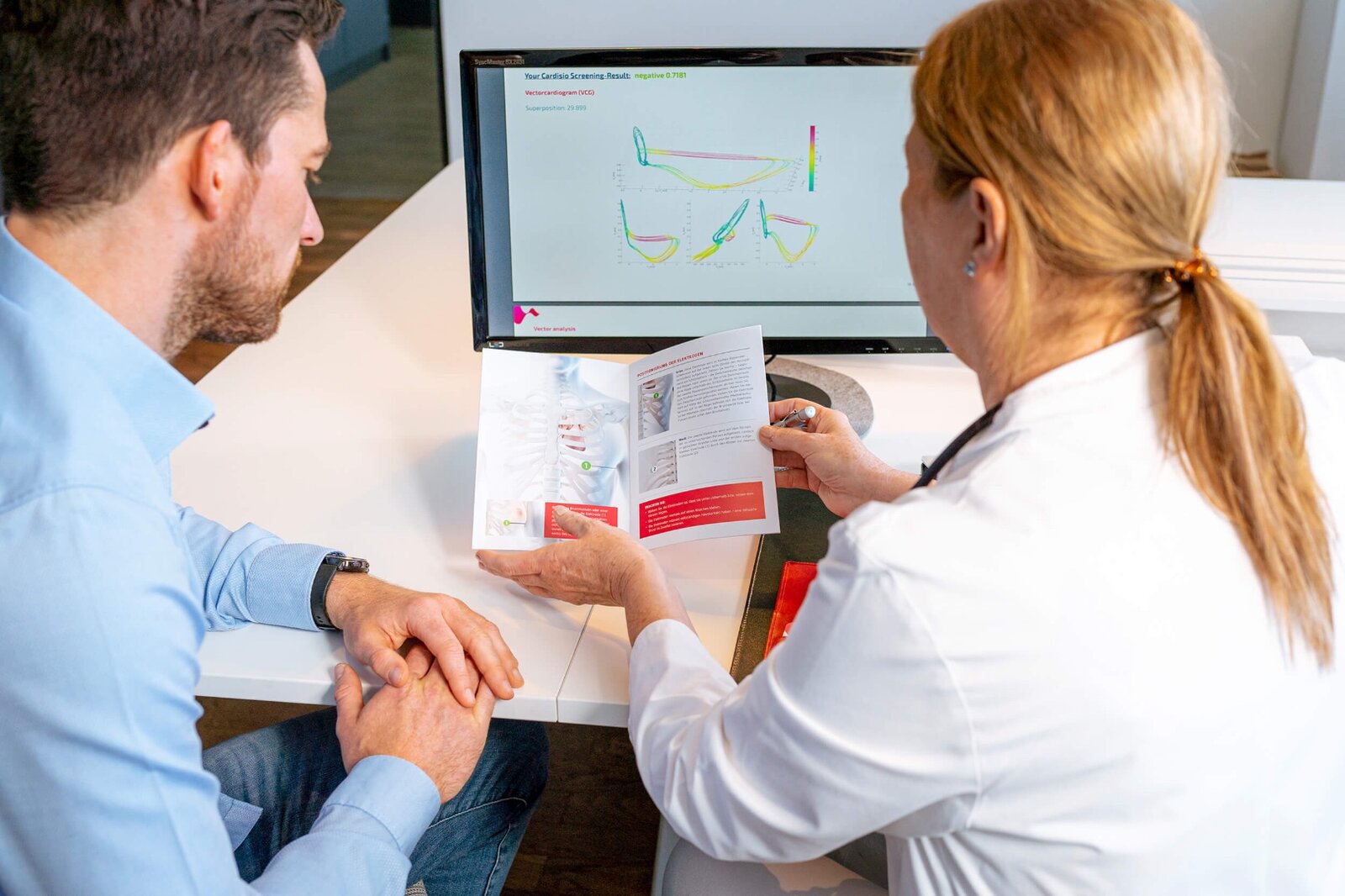 Physician and patient reviewing a Cardisio screening result on screen